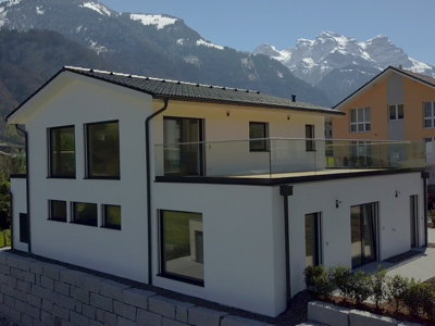 dvojpodlažný rodinný dom drevostavba postavena v Švajčiarsku s horami v pozadí