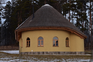 žlté hlinený dom so slamenou strechou, oblúkové okná